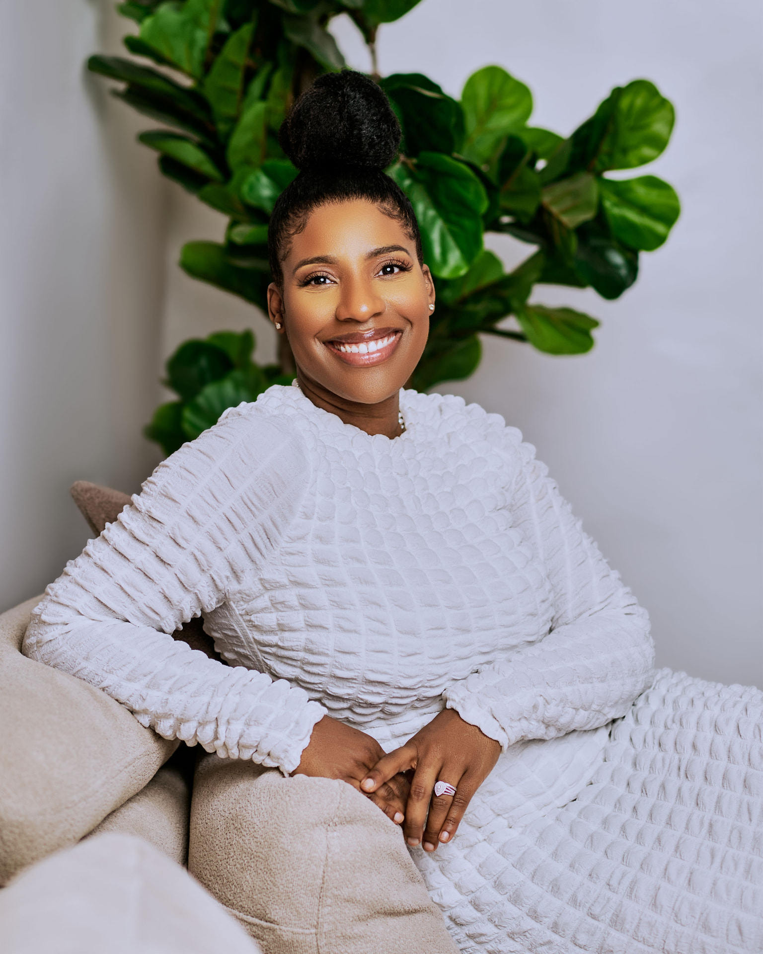 Ashlee Sunday, founder of AXL Design Studio, seated in a bright neutral interior